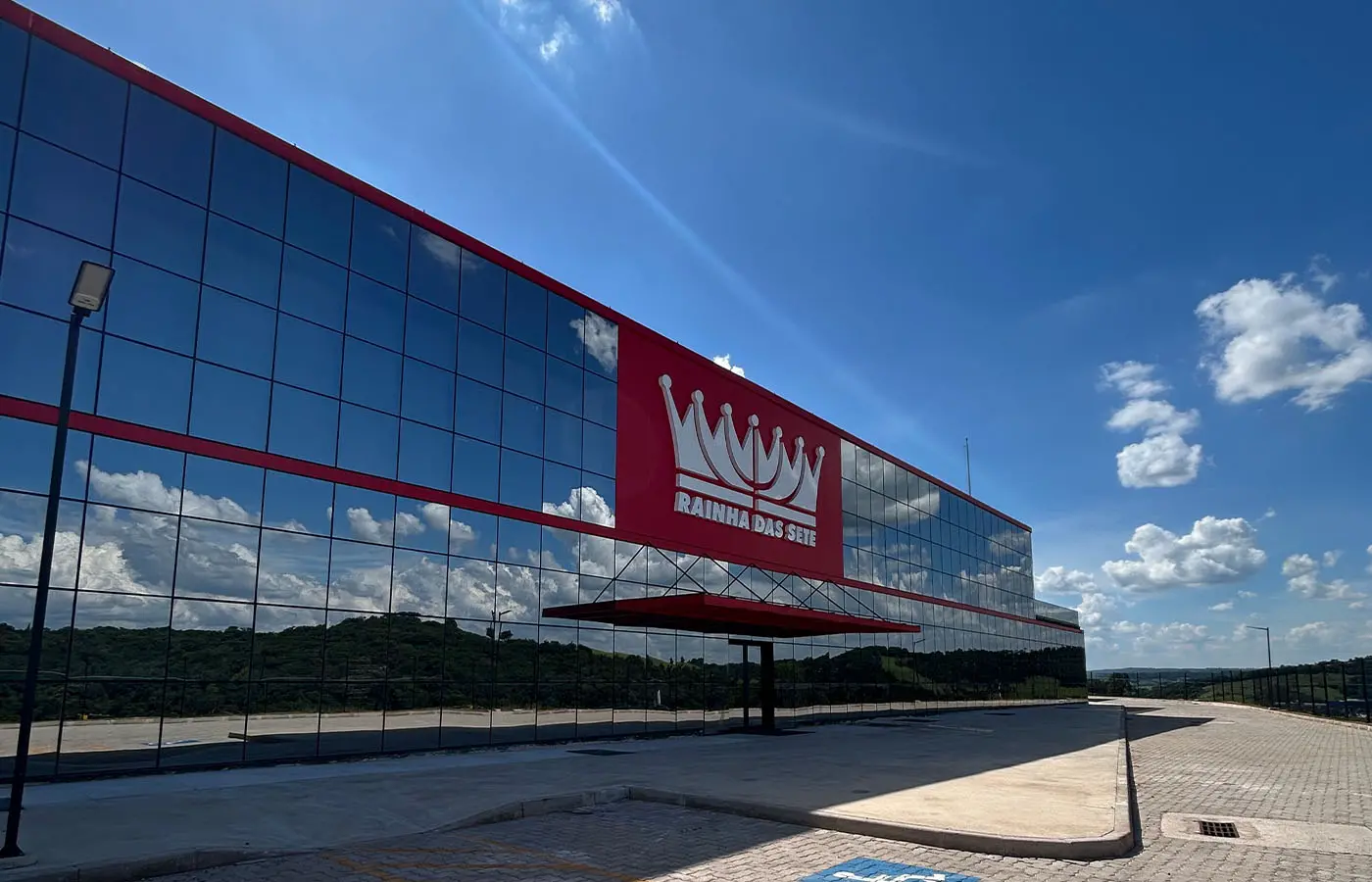 Fachada espelhada da Rainha das Sete com faixa vermelha e logo da coroa